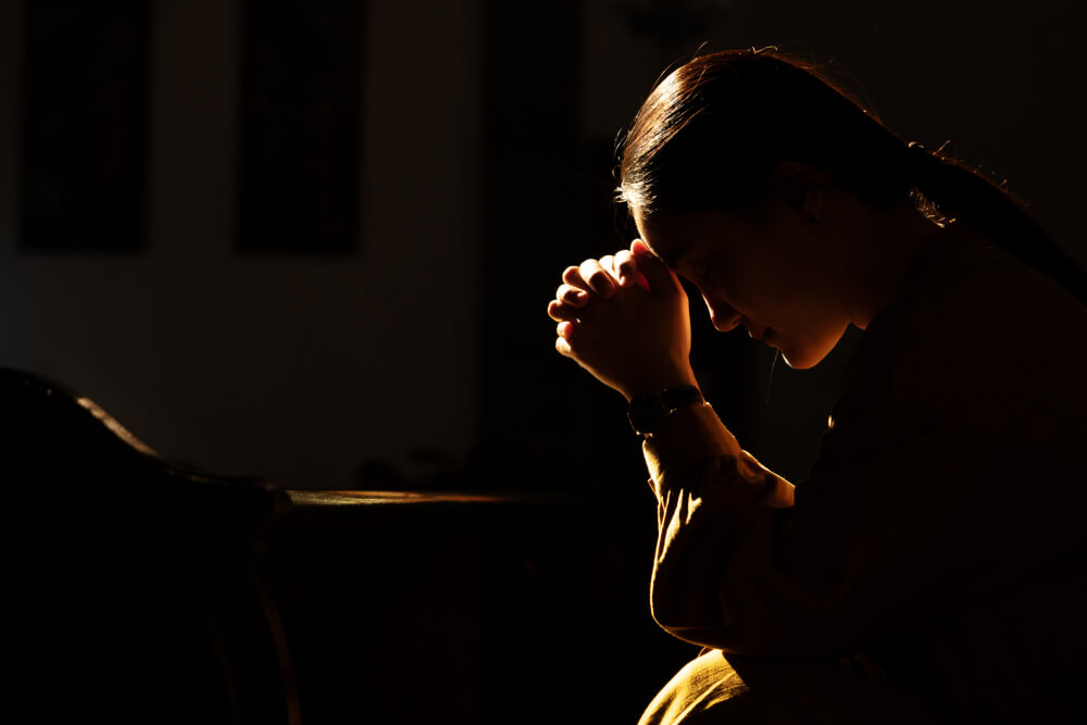 depressed-women-sitting-in-the-low-light-church-and-praying-international-human-rights-day-concept
